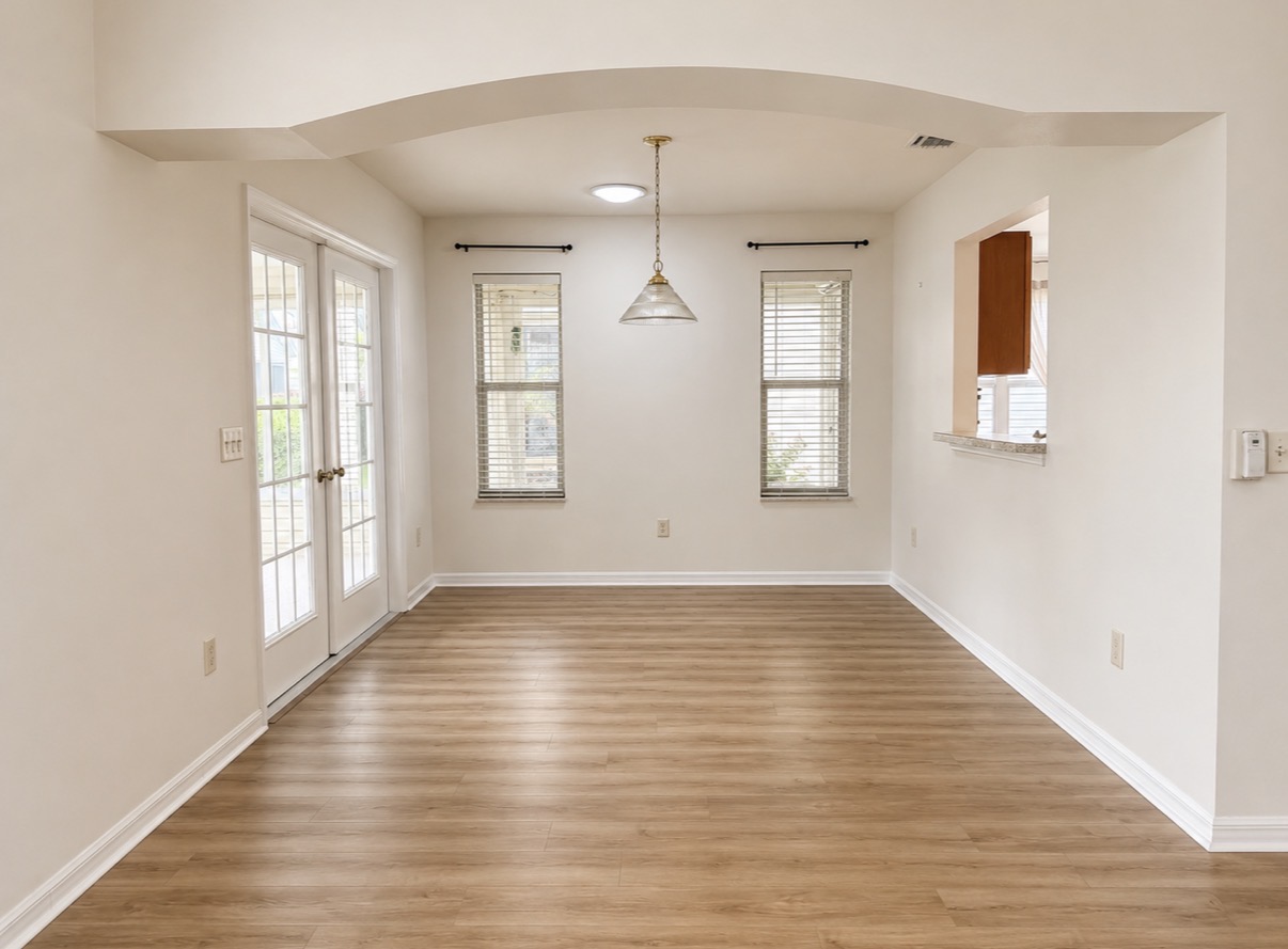 Sunlit dining nook with arched ceiling and French doors