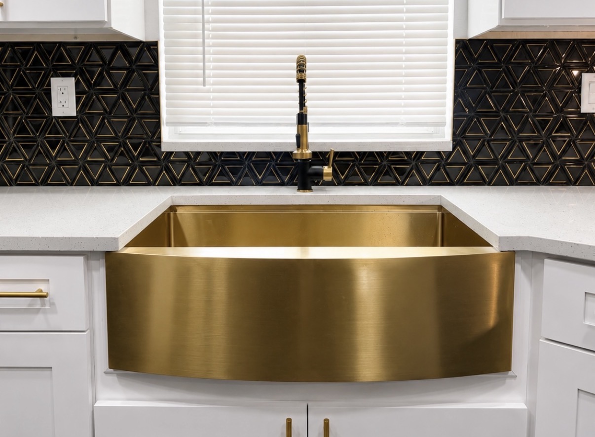 Brass apron-front sink against geometric black tile backsplash
